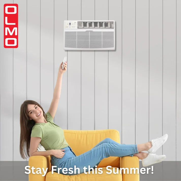 Woman sitting on a yellow chair using a remote control with an air conditioner on the wall, OLMO brand visible.